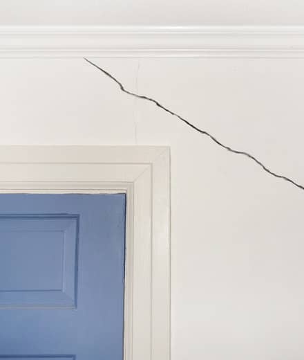 Large crack in wall above doorway