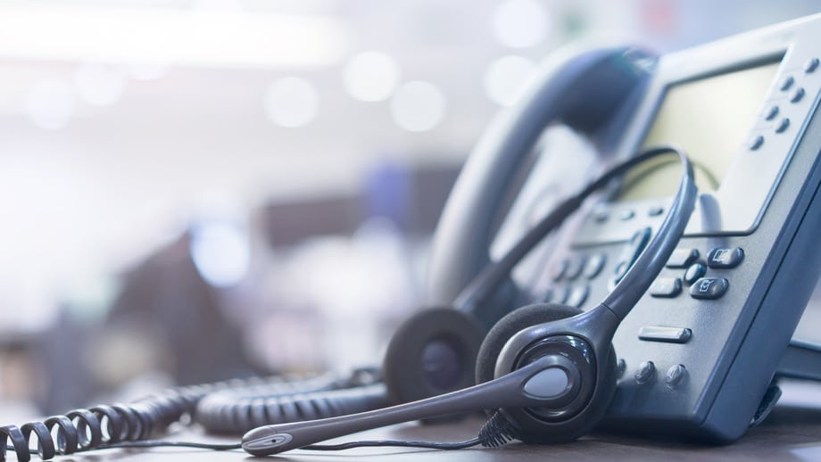 Customer client support phone and headset on table