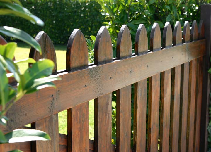 Dark stained wooden fence in backyard